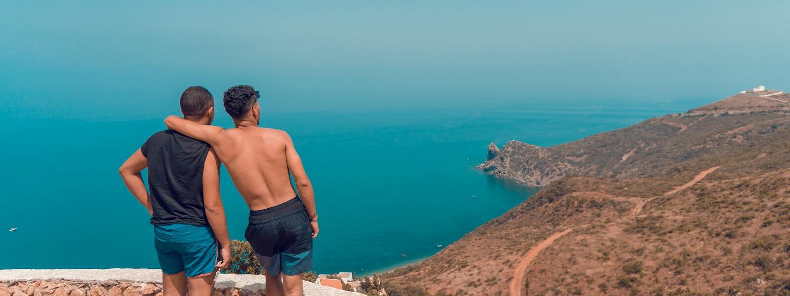 Two men enjoying a scenic view over the coastline of Chefchaouen, Morocco.